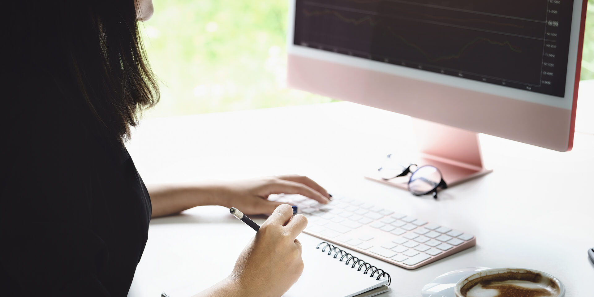 New normal, self-employed women hand holding pen are using notebook and computer laptop to trade stocks for profit, buying and selling