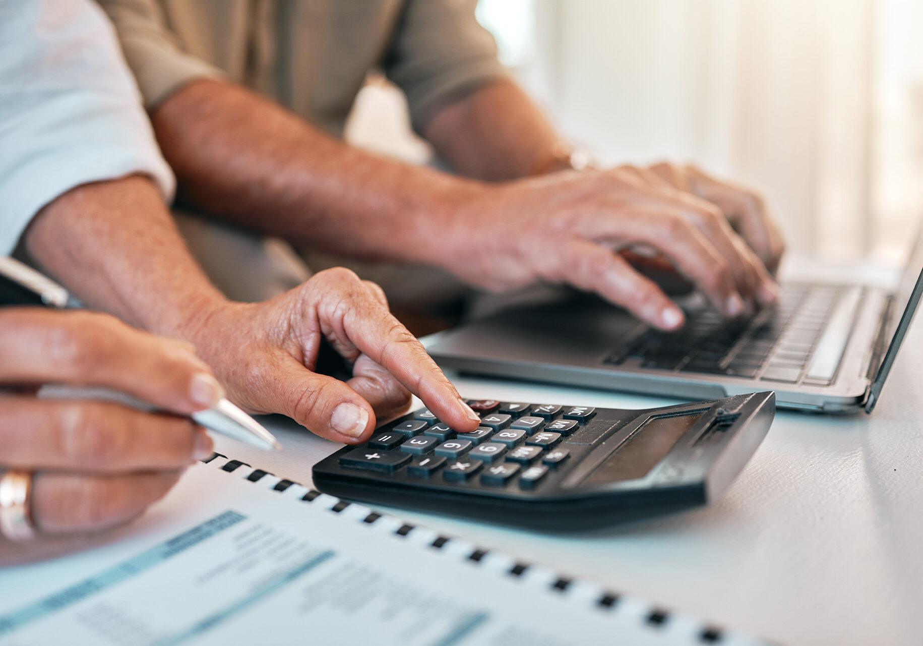 Hands, laptop and calculator for a home budget, planning retirement or online payment for banking. Accounting, couple or people with financial research, mortgage or analysis of tax paperwork.